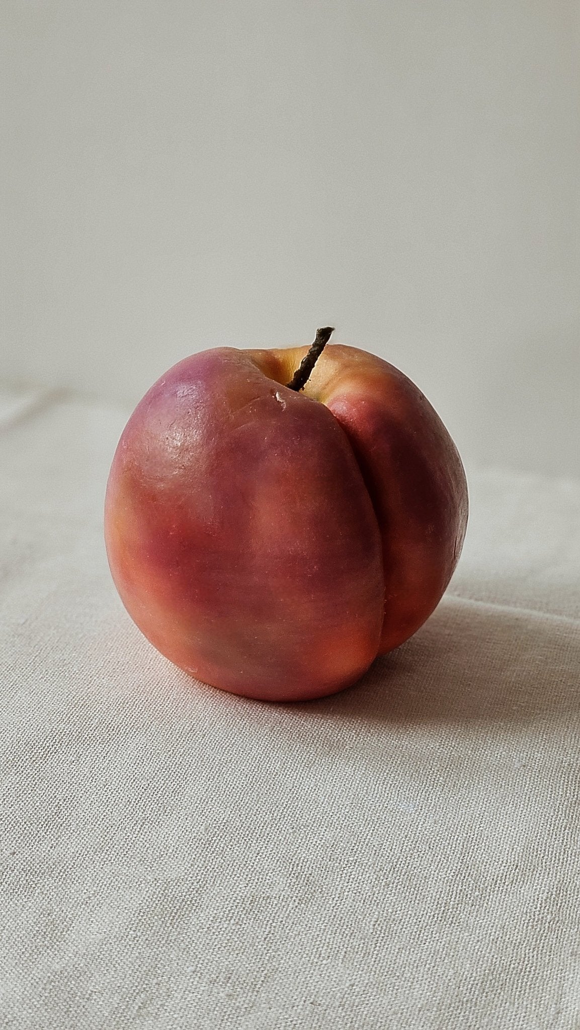 hand-poured round peach candle on white background