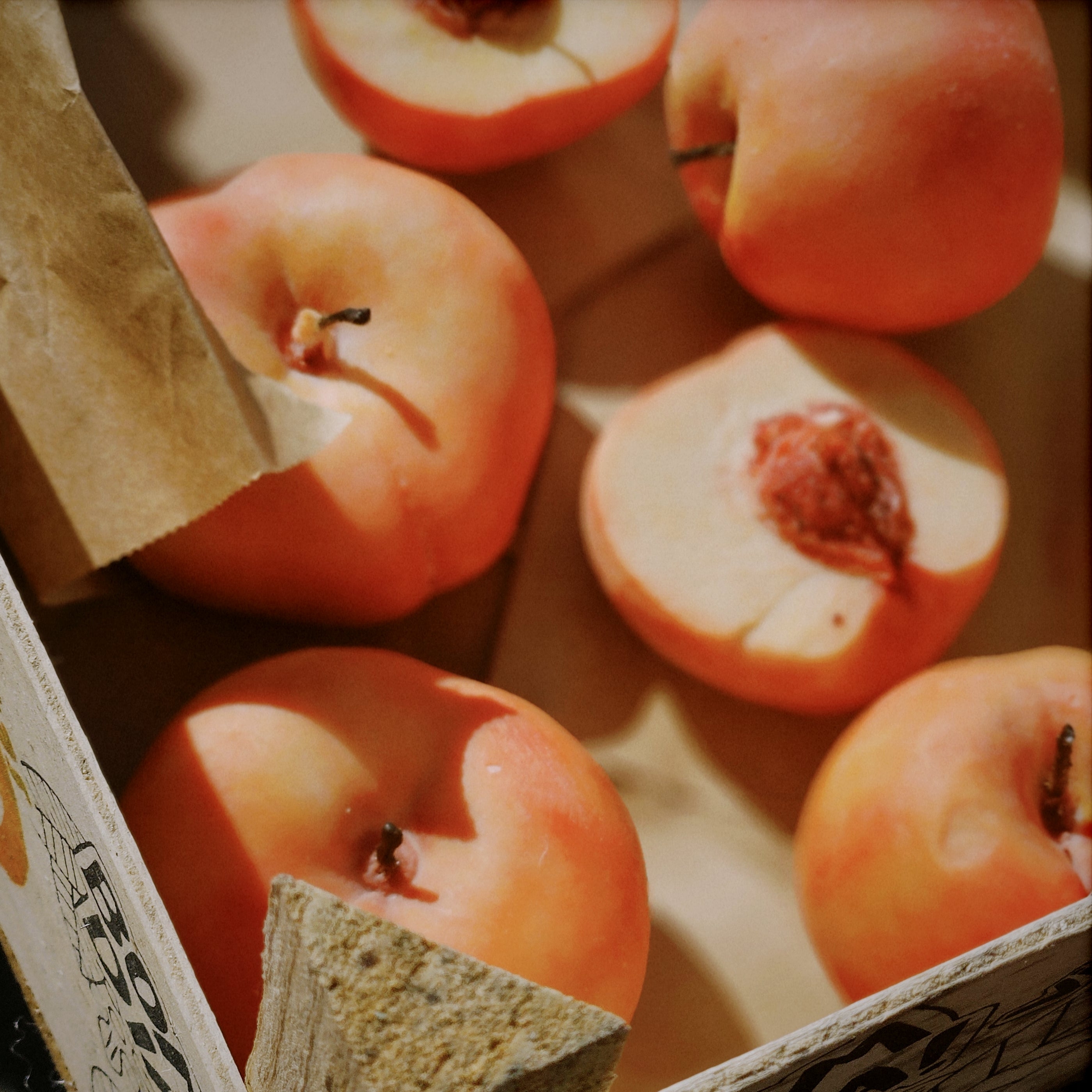 hand-poured round peach candles in a crate